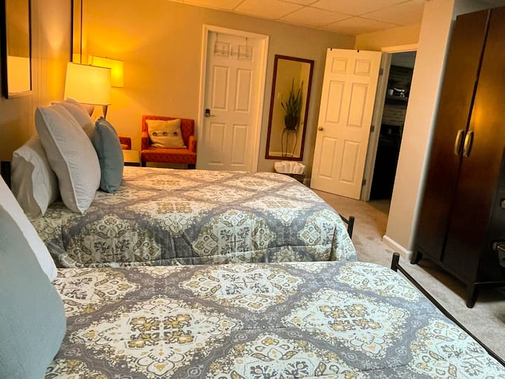 Шеста голяма спалня с две двойни легла и два акцентни стола за разпускане.