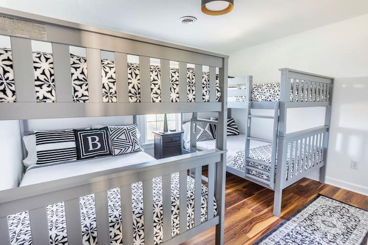 The "berth deck" (bunkbed room).  4 full size mattresses sleep 4-8 "buccaneers"! EACH bed is said to hold a MAXIMUM of 400 pounds! This room also boast a  55" Smart TV,  and a nightstand charging station with 4 plugs, 1 USB C, and 4 USB ports!