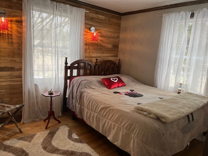 The second bedroom upstairs has a queen bed and fun red crystal sconces. 