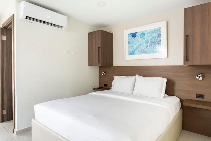 El dormitorio tiene una cama tamaño king que puede alojar cómodamente a dos huéspedes.
Este dormitorio está equipado con almacenamiento de ropa, TV inteligente, lámparas de noche, plancha (en el armario) y aire acondicionado.