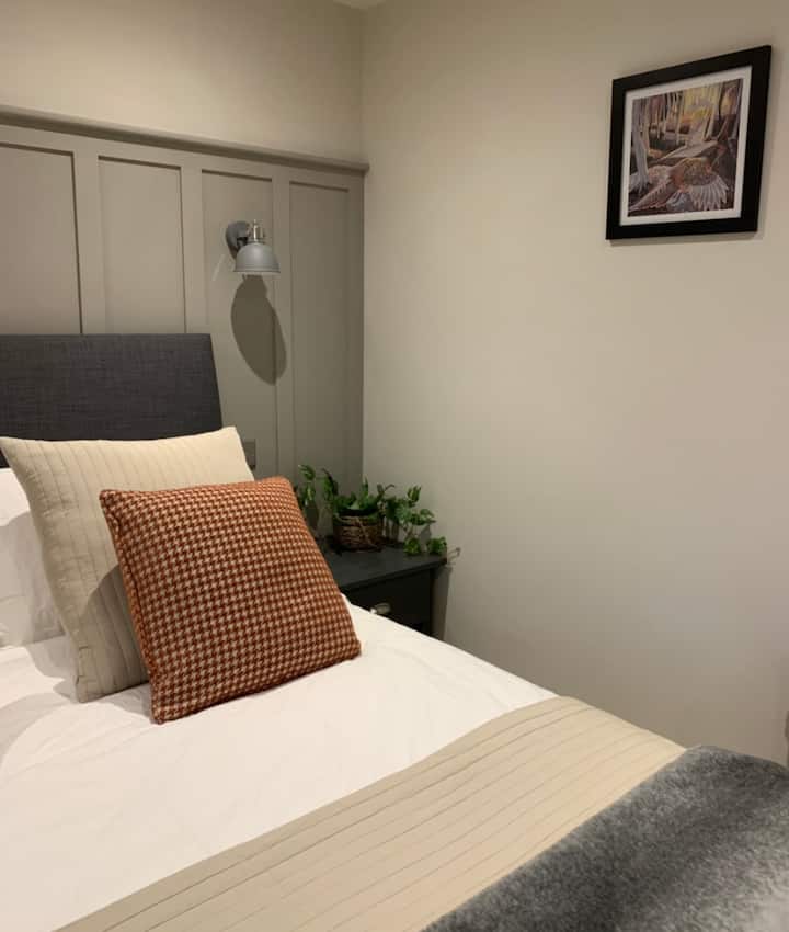 นอนบนเตียงขนาดคิงไซส์นอนซุกตัวอยู่ใต้เครื่องนอนผ้าฝ้ายสีขาวที่กรอบ ห้องพักนี้หรูหราอย่างแท้จริงและเหมาะสำหรับการพักผ่อนสุดโรแมนติก  