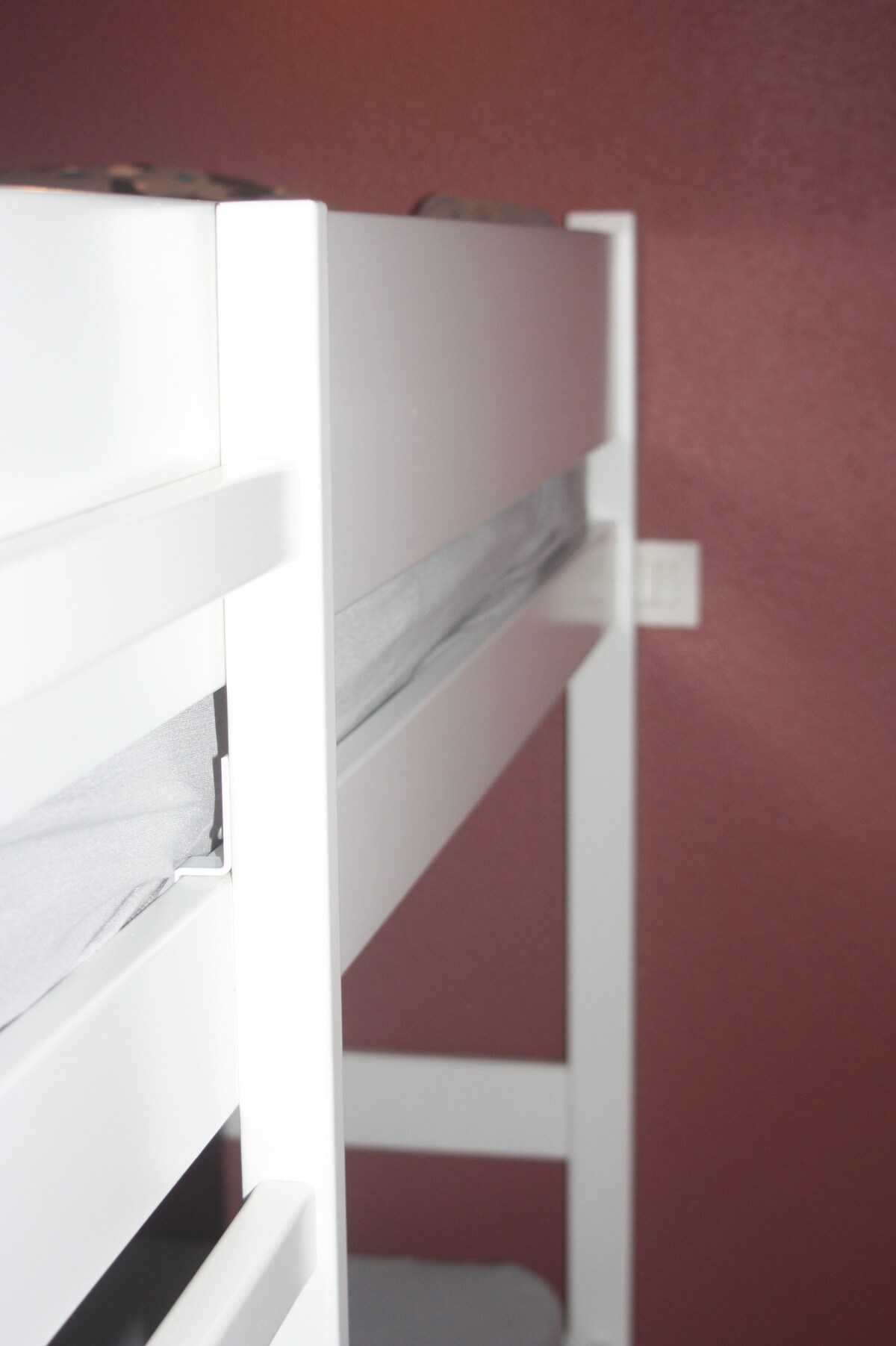 Mala spavaća soba s malim prozorom s pogledom na hodnik i krevetom na kat