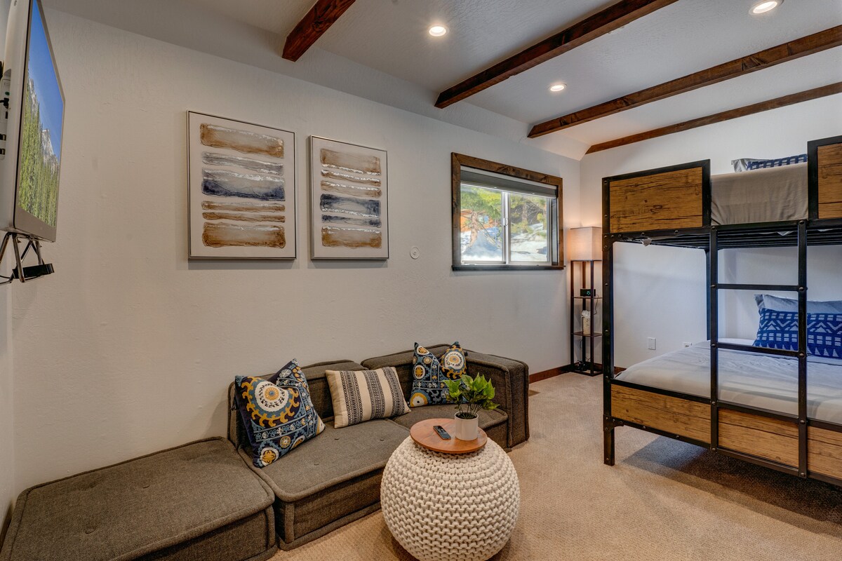 Justo al otro lado del pasillo de la habitación king de abajo, esta acogedora habitación con literas cuenta con una litera completa, un sofá seccional y un televisor inteligente, perfecto para niños o invitados adicionales.