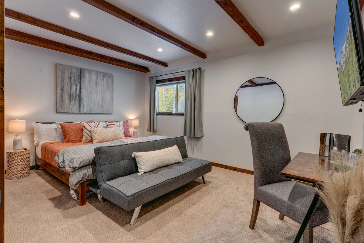 Este dormitorio cuidadosamente diseñado combina comodidad y funcionalidad con una cama tamaño king, un sofá estilo futón, una estación de maquillaje/escritorio y un televisor inteligente de pantalla plana. Ideal para parejas, trabajadores a distancia o padres que necesitan un espacio tranquilo para relajarse cerca de los niños.