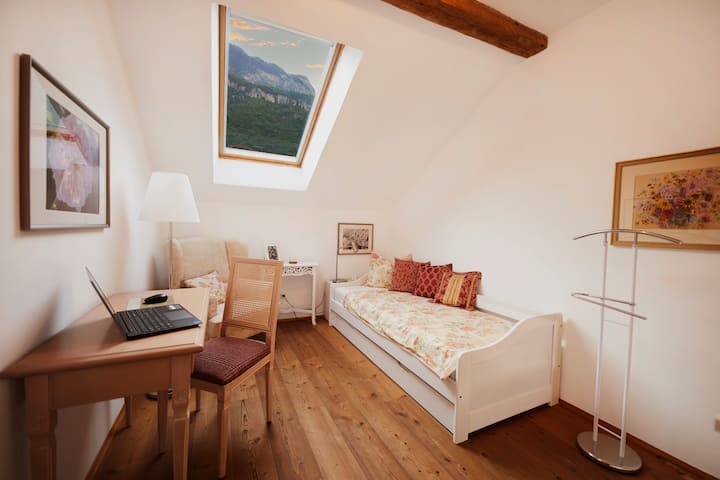 Dormitorio con cama individual con vestidor y espacio de trabajo. 
