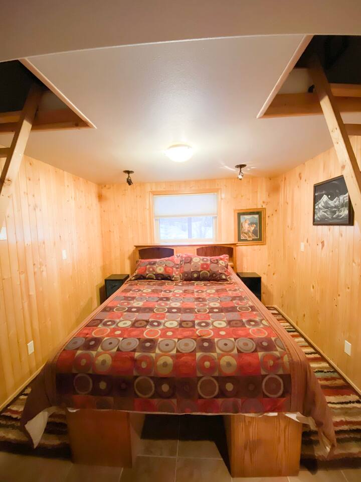 This is the one bedroom, with the queen bed. On either side of the bed is a ladder that leads to the 2 small lofts, each with a twin mattress. For guests with babies, a pack & play will fit on either side of the bed.