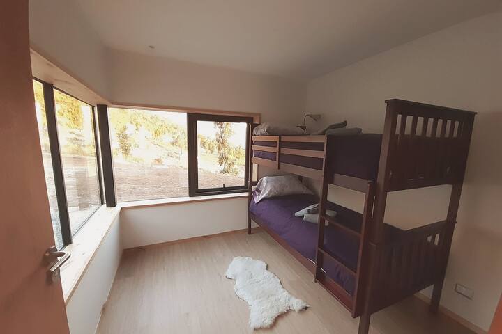 Troisième chambre avec lit superposé donnant sur la forêt indigène et la chaîne de montagnes