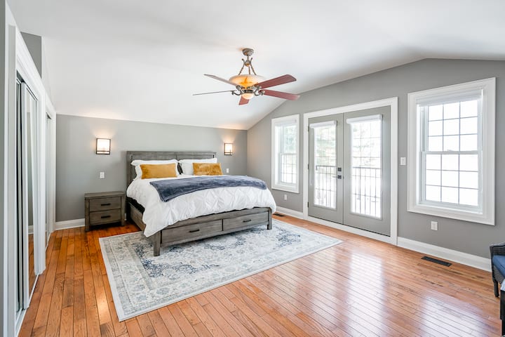Second level Master King bedroom with clean linens, large closet, ceiling fan, bedside lighting, orchard views, window covering blinds, conversation seating. 