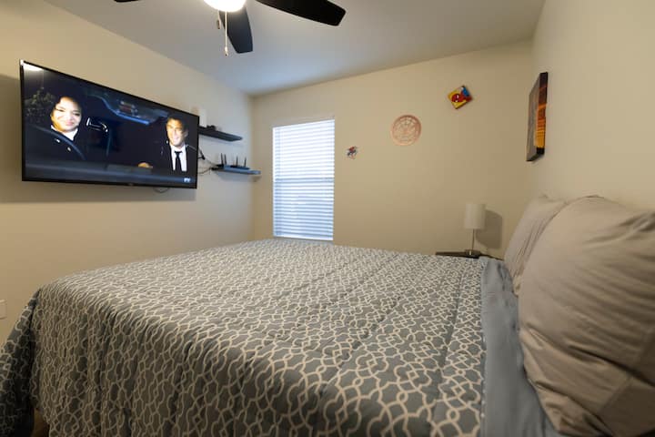 Kitanda aina ya Queen na televisheni kubwa yenye intaneti ya kasi katika chumba hiki cha wageni chenye mandhari ya Marvel