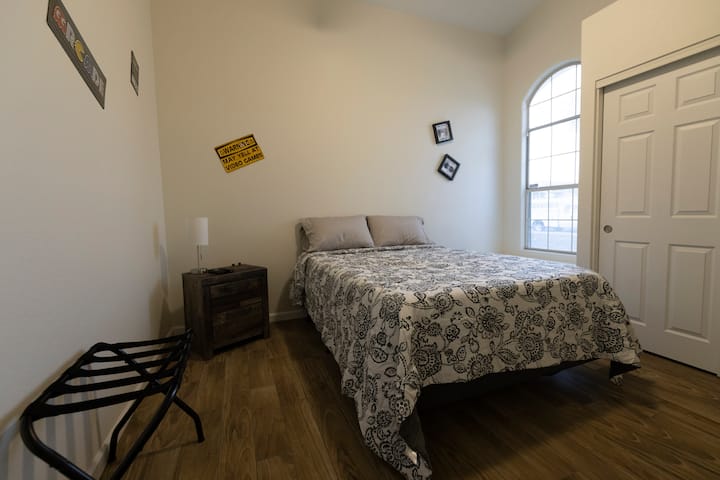 Mizigo ya mwanga katika chumba hiki cha wageni chenye mandhari ya michezo ya kubahatisha kilicho na kitanda aina ya queen