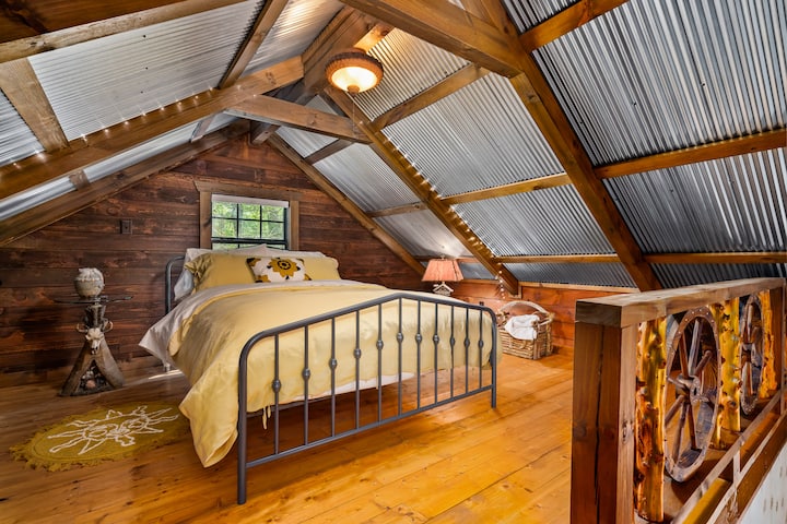 Awesome loft with fluffy comfortable bed and linens. twinkle lights and cool antique lights and table.
