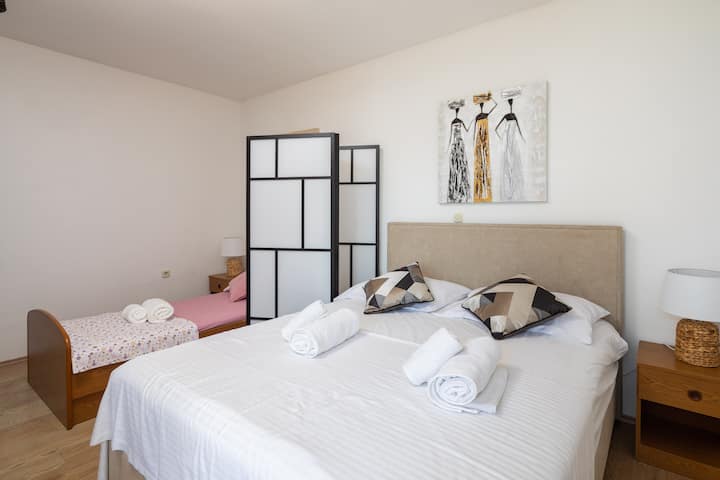 ห้องนอนพร้อมเตียงคู่ขนาดใหญ่ 1 หลังและเตียงเดี่ยว 1 หลัง