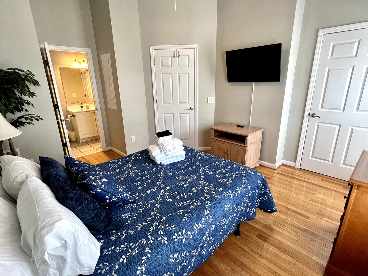 ห้องนอนชั้นล่างพร้อมเตียงขนาดควีนไซส์และห้องน้ำเต็มรูปแบบ