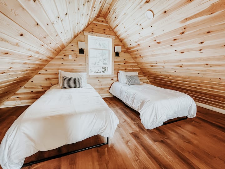 ห้องใต้หลังคาชั้นบนพร้อมเตียงคู่ 2 หลังเข้าถึงบันไดห้องสมุด 