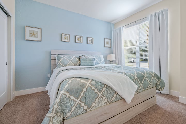 Predivna spavaća soba s ukrasima u svjetlosnim tonovima i pogledom izvana.