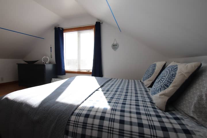 2nd main bedroom.  Queen bed, Twin single bed, and a Desk.  A light and sunny room with a  view of the garden, harbour and ocean.