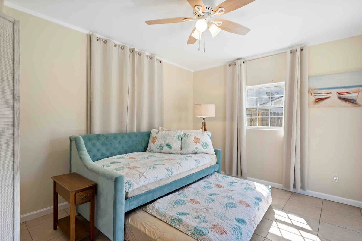 Serenidad del solárium de Pensacola: un acogedor nido doble te espera, que ofrece un espacio perfecto para dormir para los niños en medio del encanto iluminado por el sol.