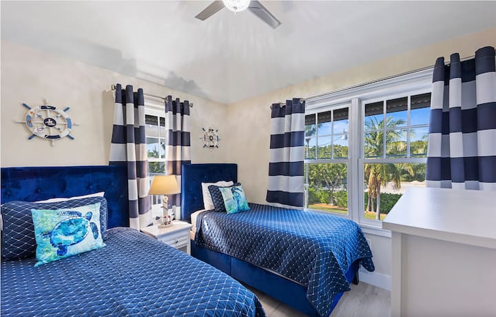 غرفة نوم ثانية بسريرين مزدوجين وتلفزيون تي سي إل سمارت 4 K 55 بوصة.