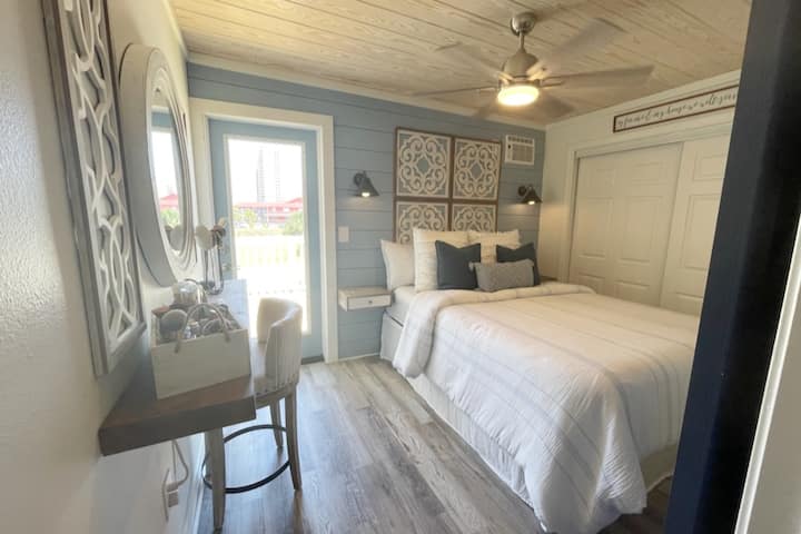 غرفة نوم بسرير بمقاس كبير وخزانة ملابس وشرفة من الباب إلى الخلف.