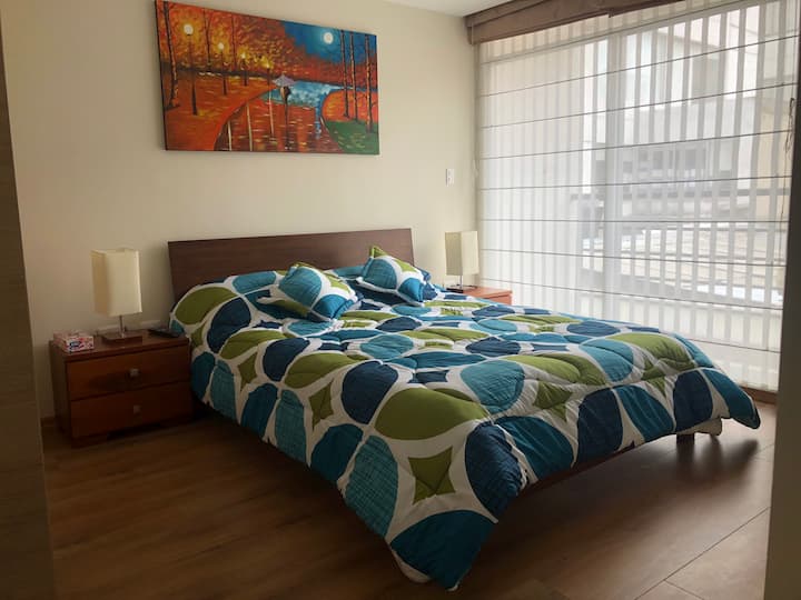 slaapkamer met queensize bed, twee kaarsen en lampen voor La Nohe