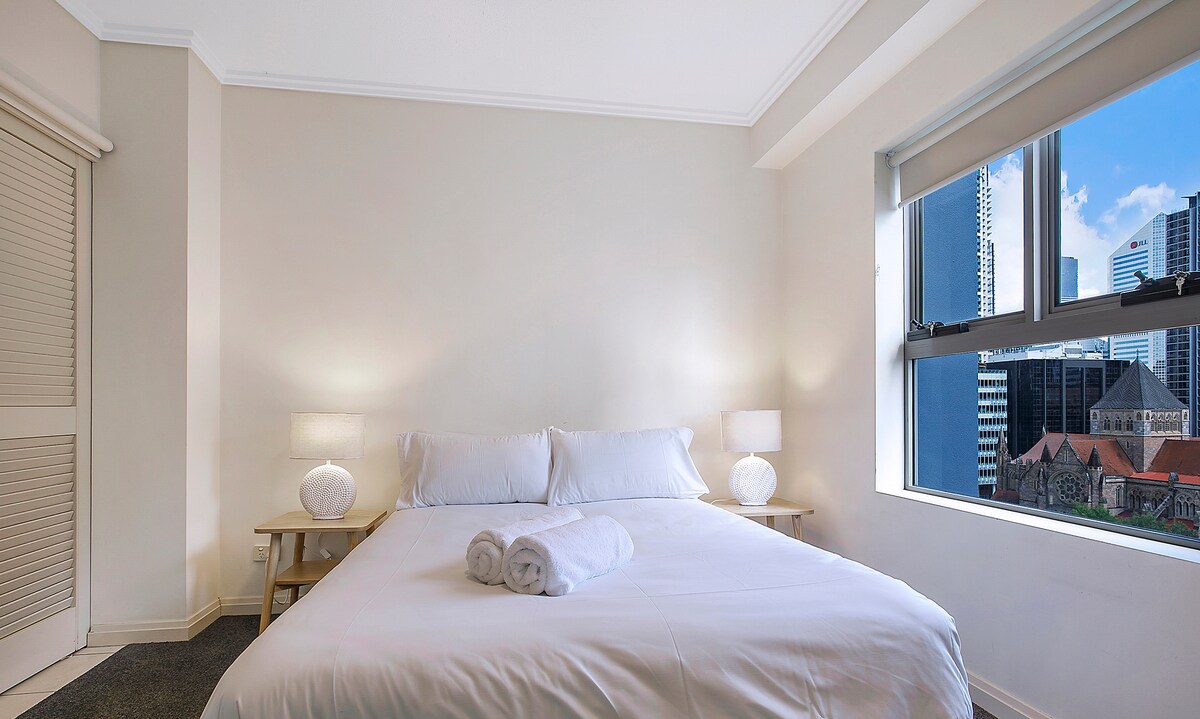 El tercer dormitorio es luminoso y cómodo con una cama doble y vistas a la ciudad.