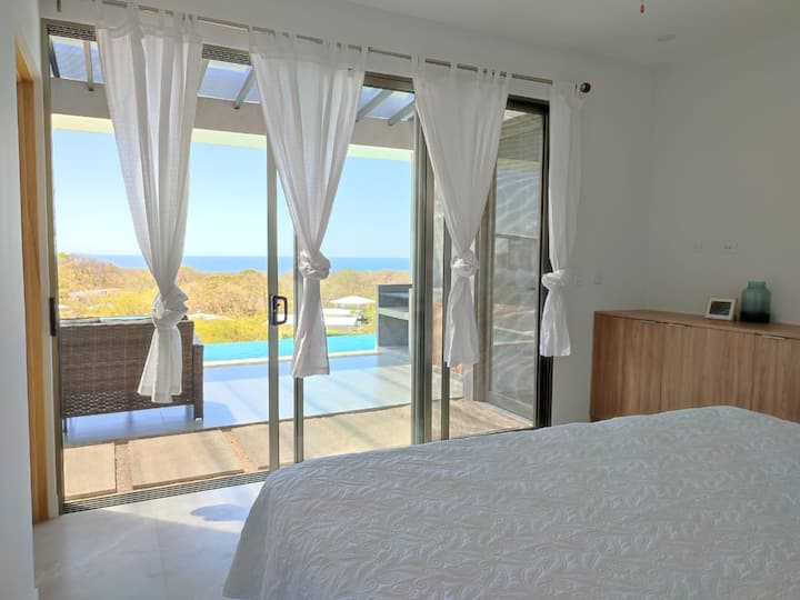 Dhomë gjumi kryesore me krevat dopio "king-size" dhe pamje nga oqeani.