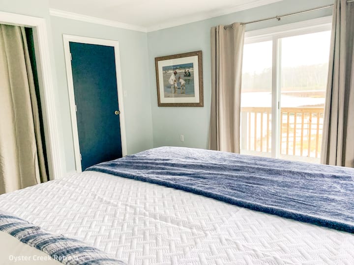 Main Floor Bedroom.  King bed, ensuite access to bathroom & beautiful water views.  Sliding door provides access to wraparound deck.