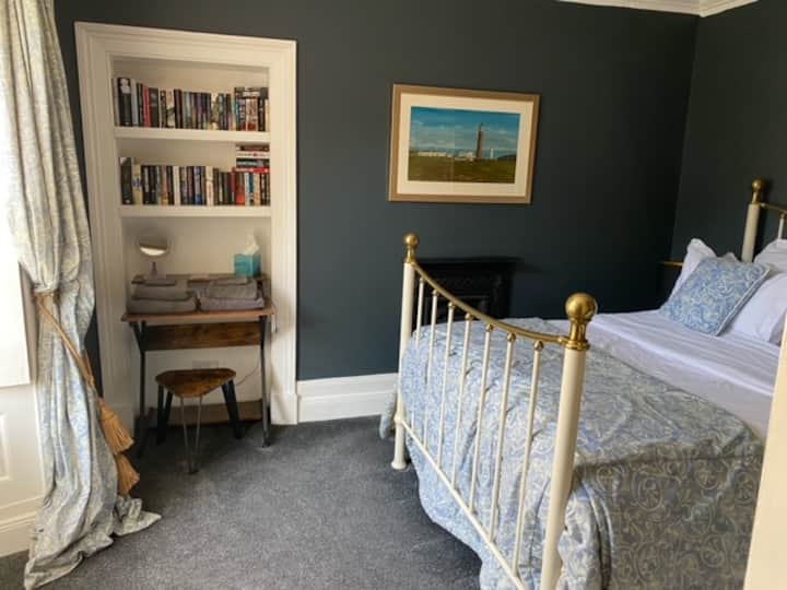 Главна спална соба со метален брачен кревет и биро. Огледало со целосна должина.