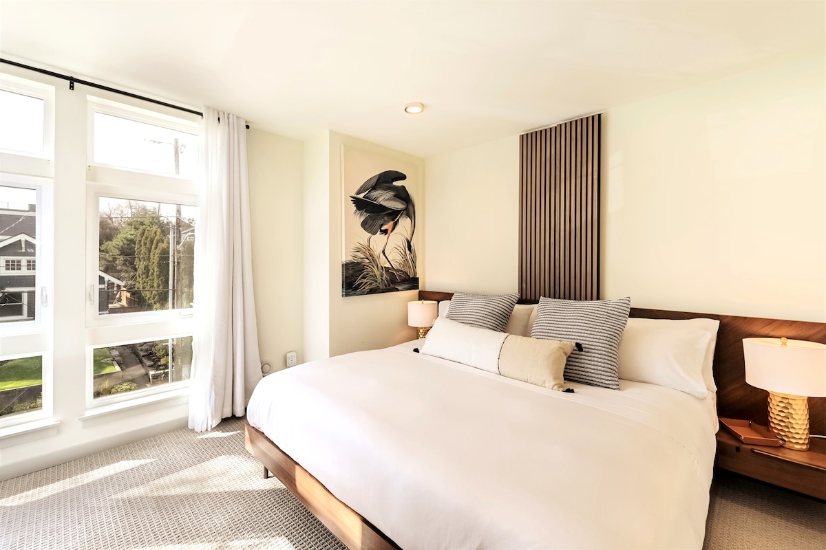 Hlavná spálňa s priestrannou priestrannou posteľou a moderným nábytkom z polovice storočia na 3. poschodí