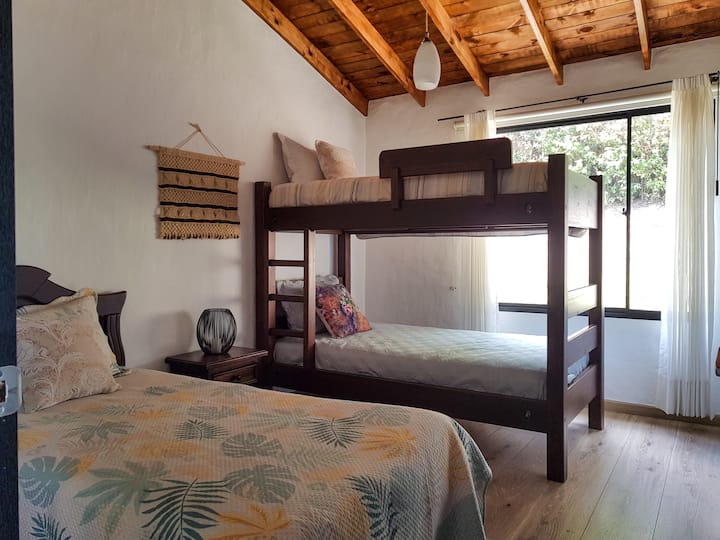 Alcoba que cuenta con una litera y una cama sencilla,  amplio y comodo armario, una ventana con vista a la naturaleza.