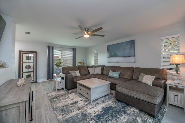 סלון מרווח עם מקומות ישיבה בשפע ואזור עבודה נפרד.