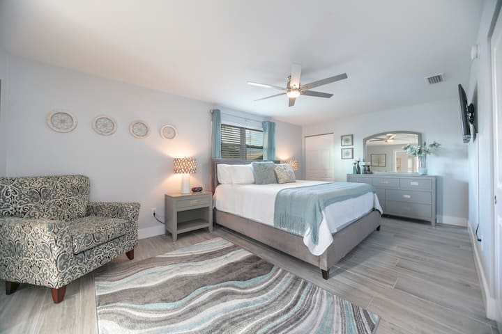 חדר שינה ראשי ענק עם מיטת קינג סייז, טונות של מקום בארון, טלוויזיה חכמה בגודל 43אינץ 'וחדר אמבטיה מקושר.