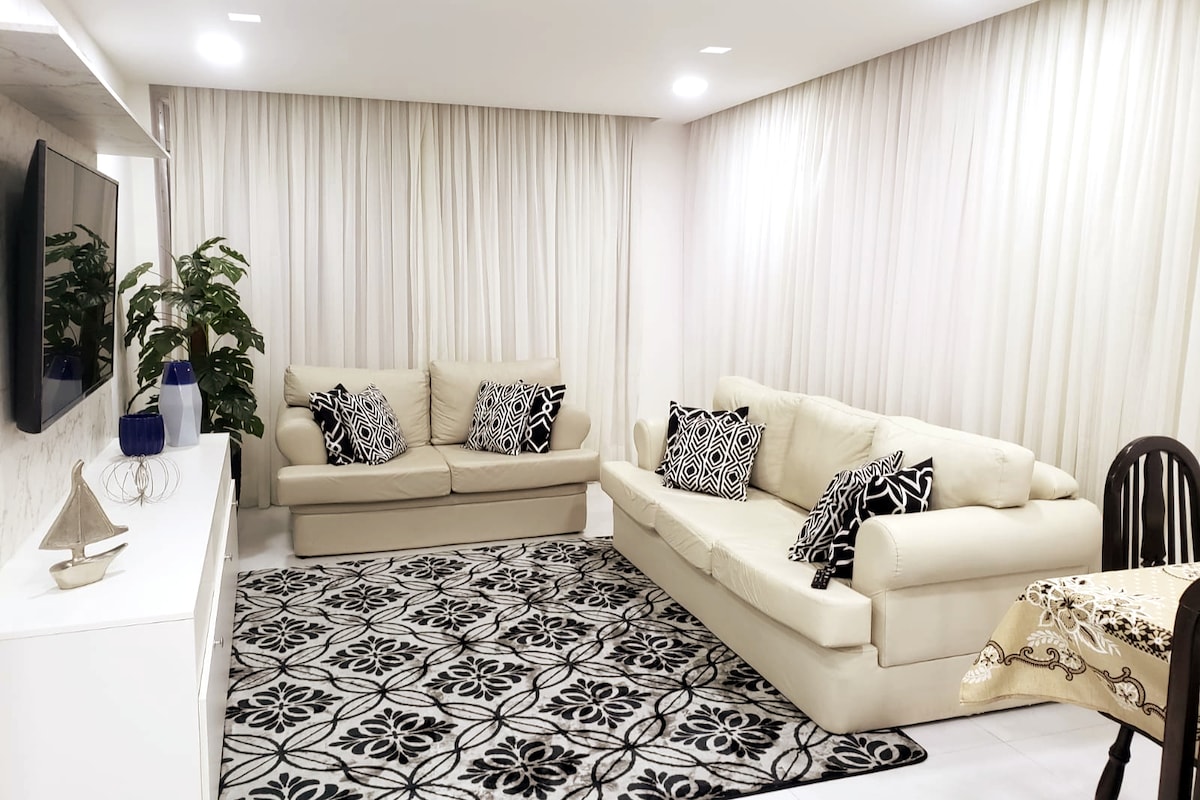 Obývacia izba s 2 veľkými oknami a výhľadom na more