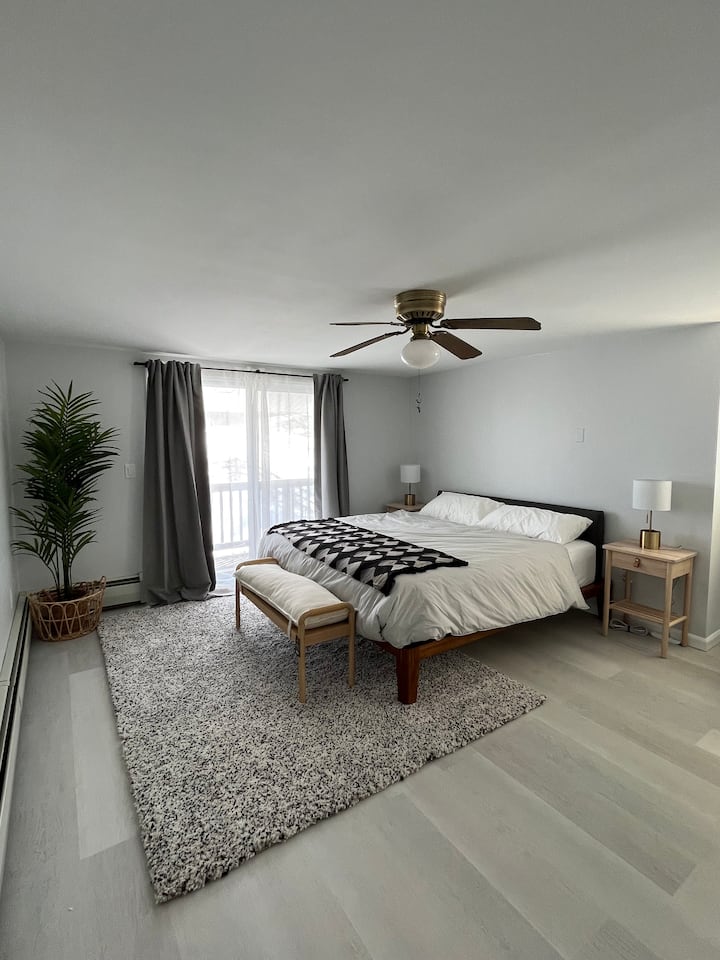 dormitorio principal con cama tamaño king y balcón con vistas a la piscina y a la montaña