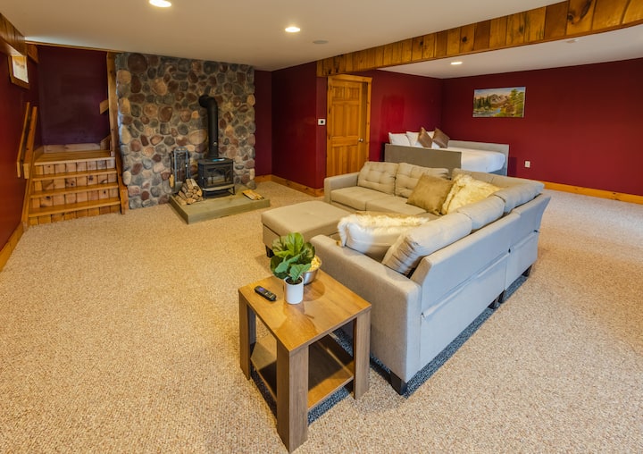 الطابق السفلي - غرفة معيشة مع مدفأة وتلفزيون وثلاثة أسرّة إضافية وسرير نهاري كامل الحجم وسرير مزدوج الحجم مع مقبض مزدوج الحجم.

هناك الكثير من المساحة في هذه الغرفة متعددة الأغراض لمشاهدة فيلم أو ممارسة الألعاب أو ممارسة اليوغا. 