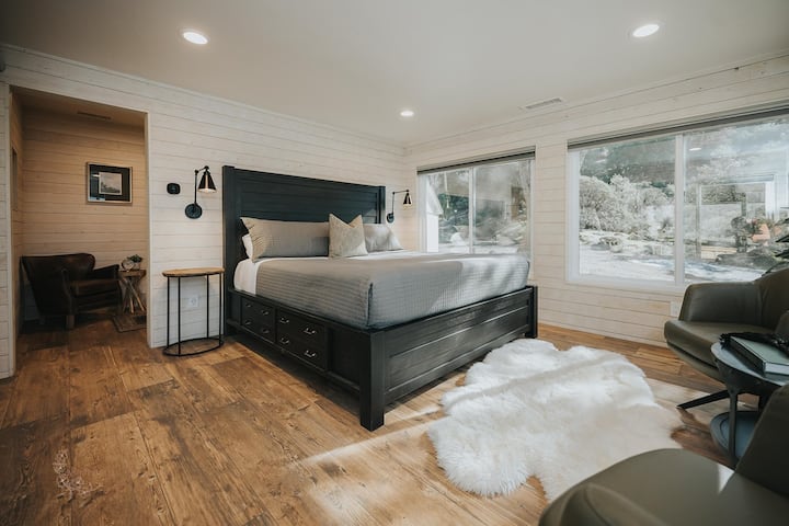 Dormitorio de casa de campo con cama tamaño king, sala de estar, vestidor y baño privado.