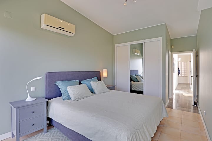 Master bedroom with wardrobe, ensuite bathroom, sliding doors to a private terrace, aircon and TV