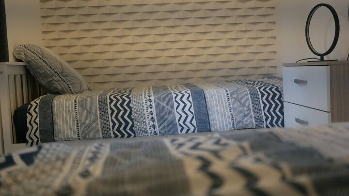 غرفة نوم بسريرين فرديين وأسرّة مصنوعة عند الوصول