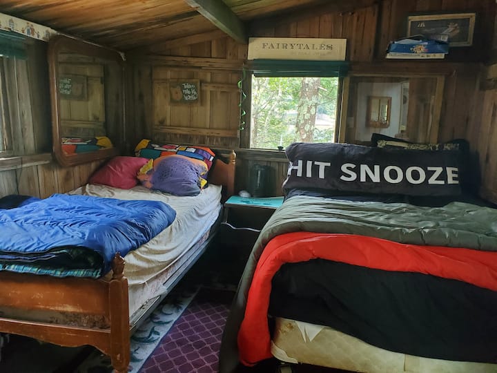 Third bedroom with king sized bed and pillow top mattress on single. Natural wood panels.