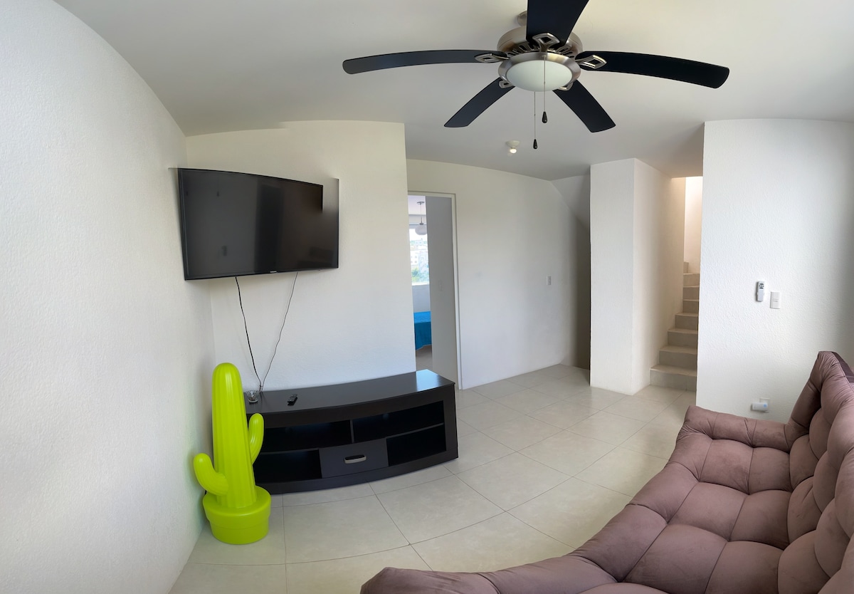 Телевизиска соба со тавански вентилатор и вентилатор за под.