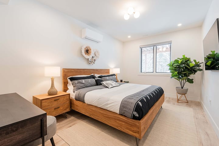 Uitzicht op de prachtige master bedroom met een kingsize bed, een smart-tv en een groot raam om de kamer warm en licht te houden. 