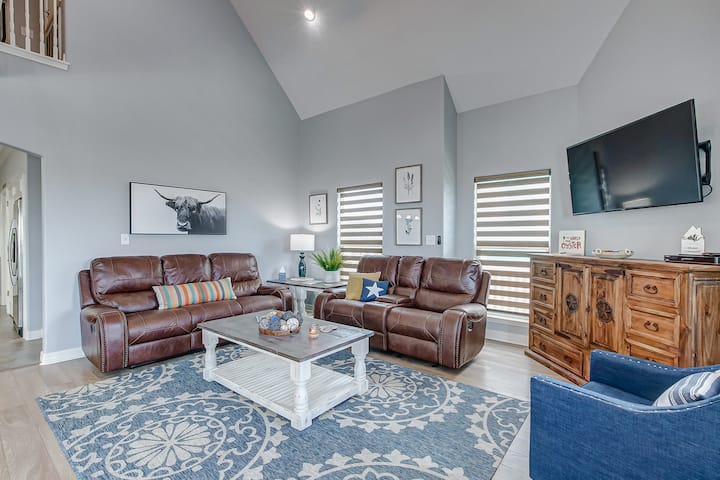 Open living area with comfy, reclining sofas and smart TV.