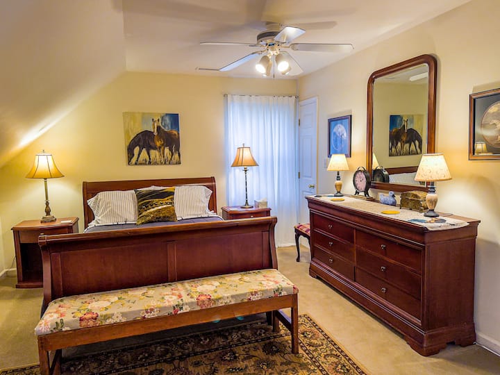 Well appointed bedroom with queen sleigh bed, 2 night stands with lamps, dresser and large mirror with lamps, ceiling fan as well as a walk-in closet. Bench seat at end of bed.  Also, has a chair and side table with lamp. Window faces the river side.