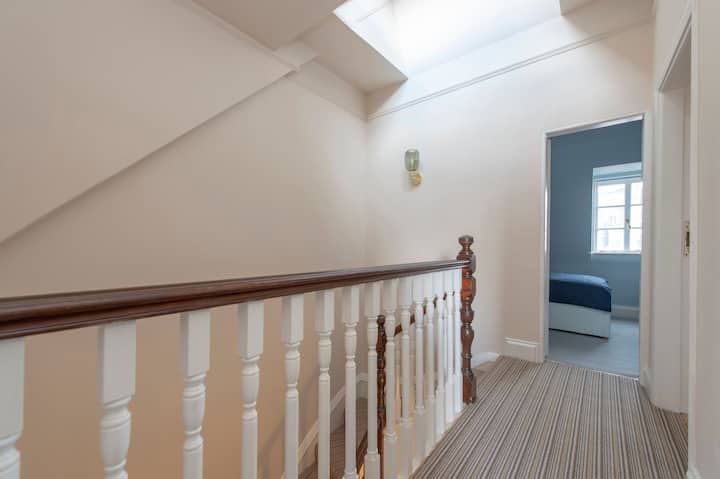 Pasillo superior, inundado por la luz natural desde las ventanas del techo, con vistas al dormitorio 4. 

Pintura natural hessiana, Orinoco Stripe 100% alfombra de lana de diseño de alfombras de diseño, lámparas de pared de cristal verde de Made