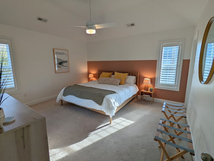 Dormitorio tamaño king con baño privado, TV, dos portaequipajes y acceso completo a la cómoda y al armario.