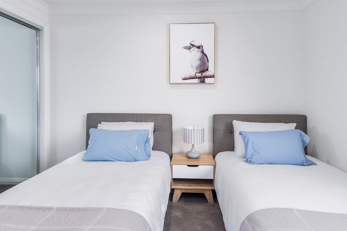 Upstairs, the fourth bedroom includes two king single beds and mirrored built-in robes. 