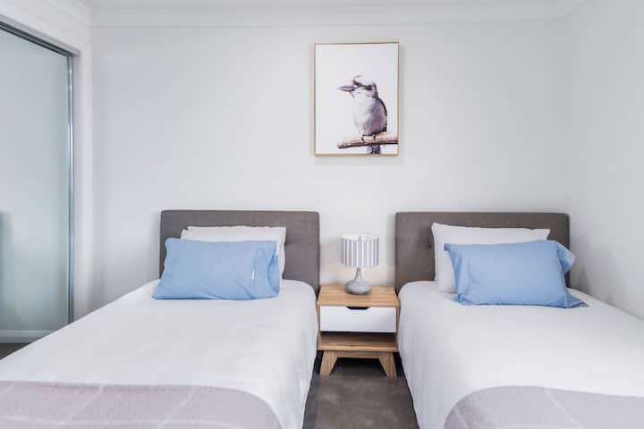 Upstairs, the fourth bedroom includes two king single beds and mirrored built-in robes. 