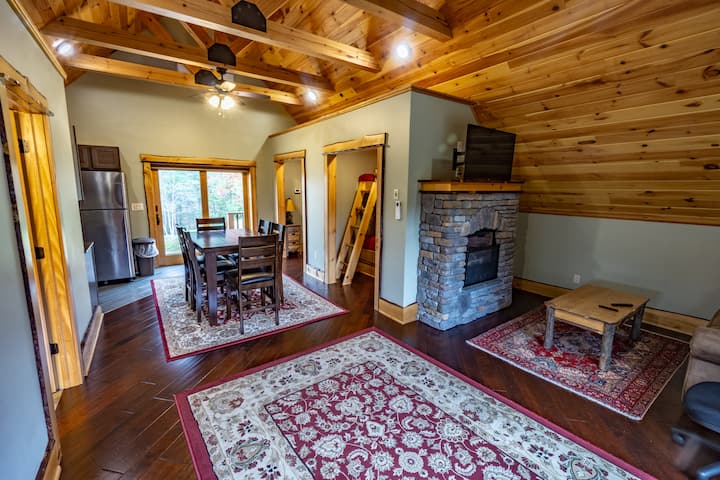 Bunk apartment has its own kitchen area, full bath, and gas fireplace. The hot  tub is just outside to the left of those slider doors. TV and couch for a small hang out area.