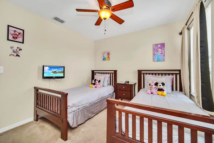 2 samostatné postele v spálni číslo 7 s televíznym stropným ventilátorom a šatníkom.