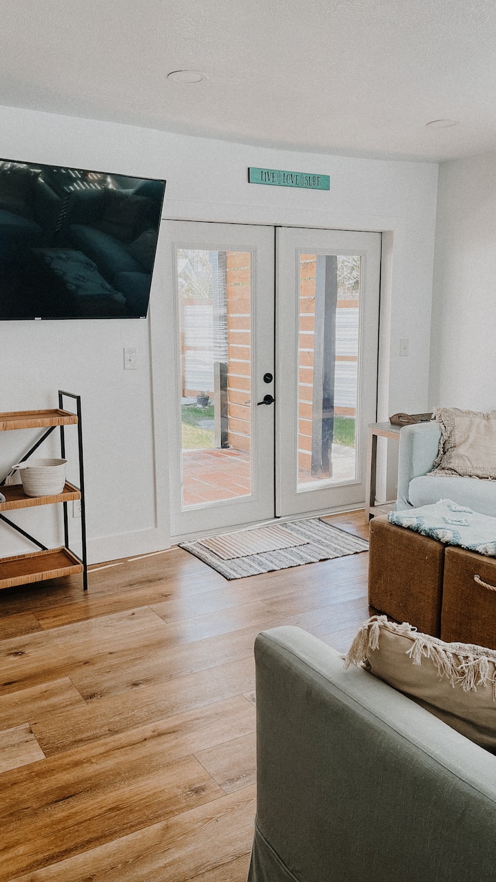 Living room has cozy couches with one that pulls out into a bed. A great space to cool off in after your day at the beach. This room is on the main level and you can find the main level bunk room right next to it.  Double doors lead to the backyard.